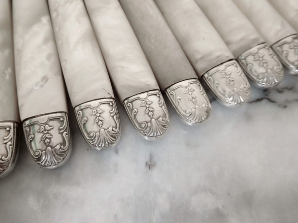 12 couteaux de table de style Louis XV, manche en nacre, viroles en argent, par Olier et Caron
