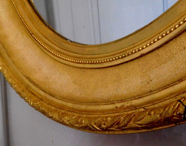 Grand miroir ovale XIXe en bois doré à la feuille d'or, glace au mercure, 82cm x 71cm