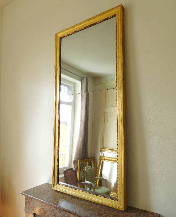Miroir d'entre deux ou trumeau d'époque Louis XVI, bois doré à la feuille d'or, glace au mercure