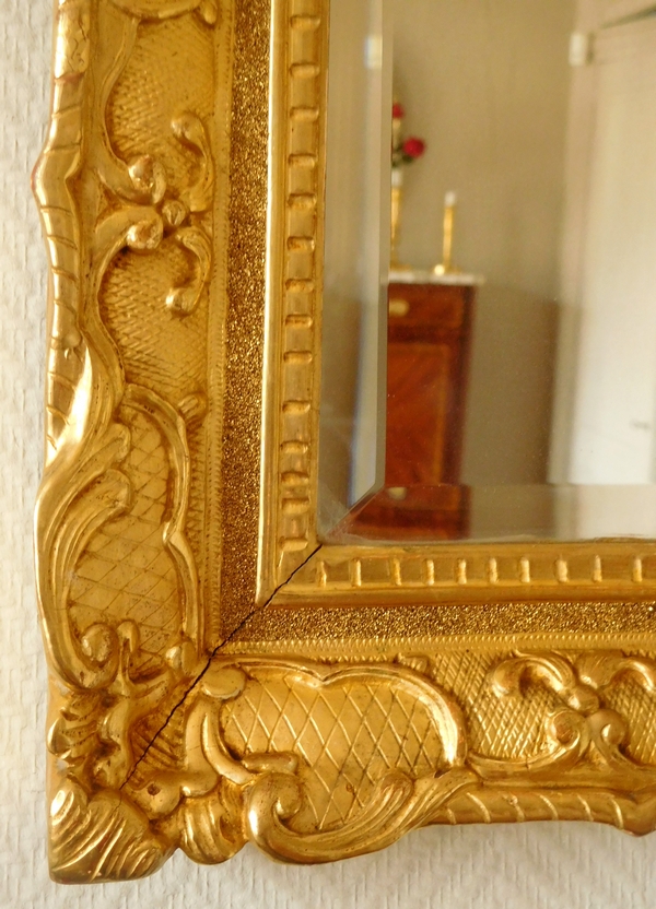 Miroir en bois doré d'époque Régence, glace biseautée
