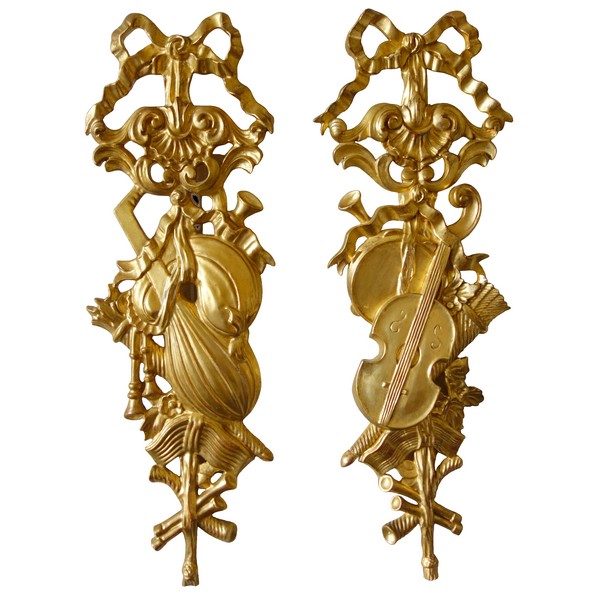 Pair of sculpted gold leaf gilt trophies, Louis XVI style woodwork