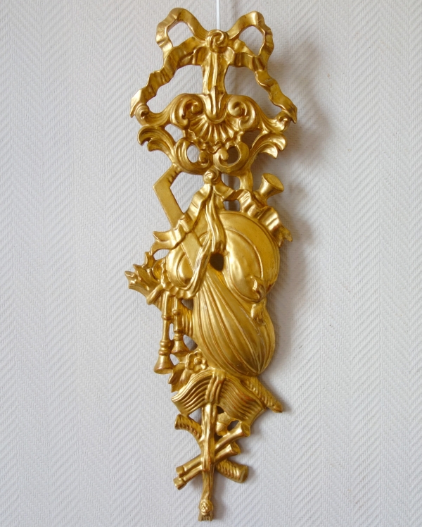 Pair of sculpted gold leaf gilt trophies, Louis XVI style woodwork