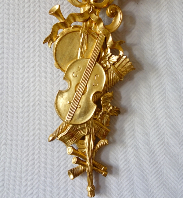 Pair of sculpted gold leaf gilt trophies, Louis XVI style woodwork