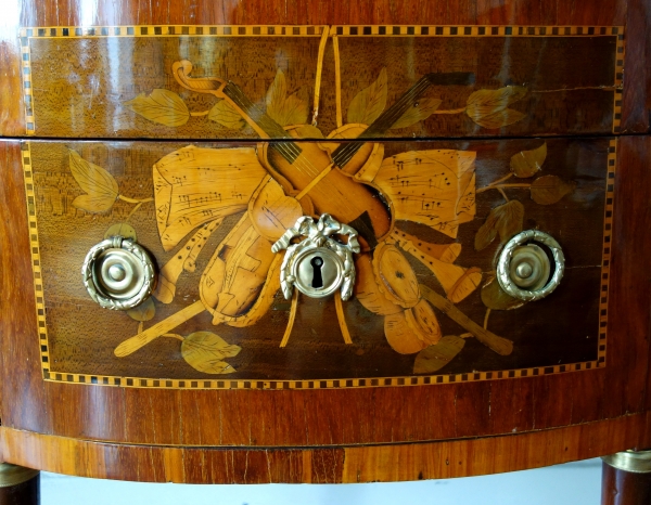 Commode demi-lune en marqueterie d'époque Louis XVI estampillée, décor de trophées de musique