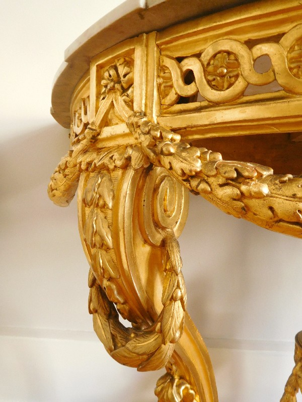 Console demi-lune en bois doré richement sculptée d’époque Louis XVI