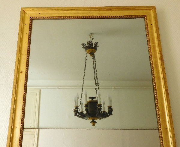 Miroir d'entre deux ou trumeau d'époque Louis XVI, bois doré à la feuille d'or, glace au mercure