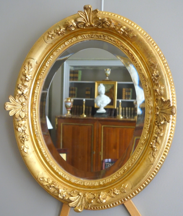 Miroir ovale de style Louis XIV, bois doré à la feuille d'or, glace biseautée - 58,5cm x 68cm