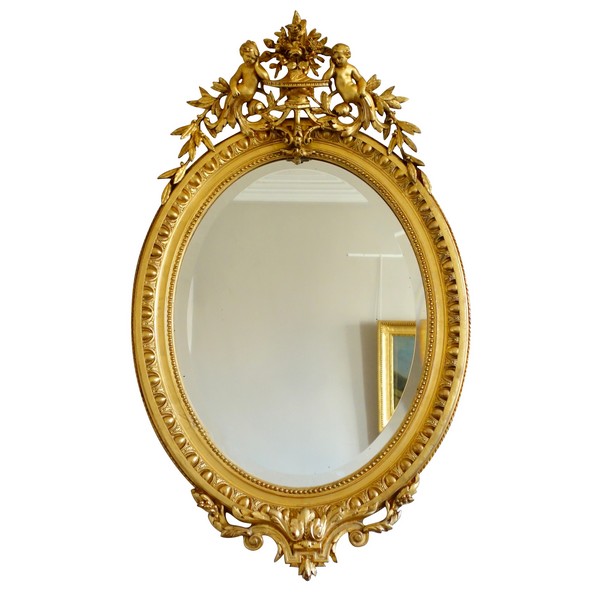 Louis XVI style gilt wood oval mirror decorated with putti, 19th century