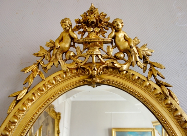 Louis XVI style gilt wood oval mirror decorated with putti, 19th century