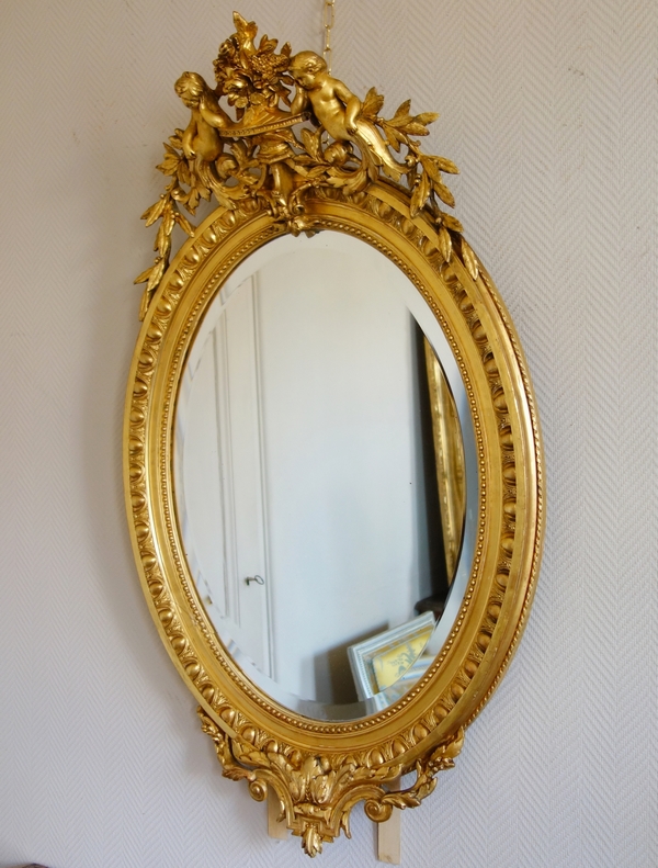 Louis XVI style gilt wood oval mirror decorated with putti, 19th century