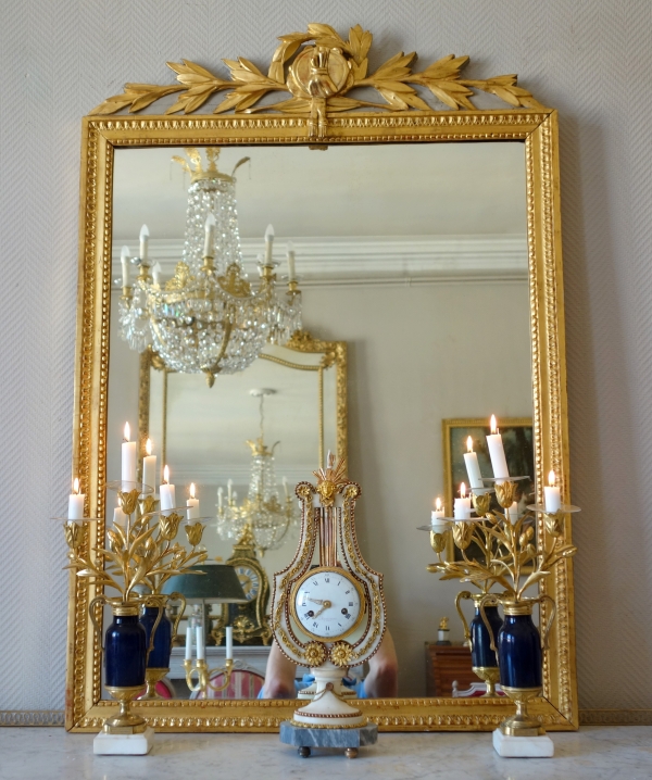 Grand miroir en bois doré d'époque Louis XVI, modèle Provençal avec fronton à trophée de musique