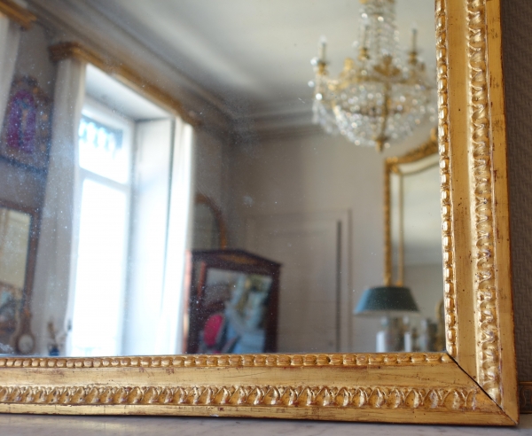 Grand miroir en bois doré d'époque Louis XVI, modèle Provençal avec fronton à trophée de musique