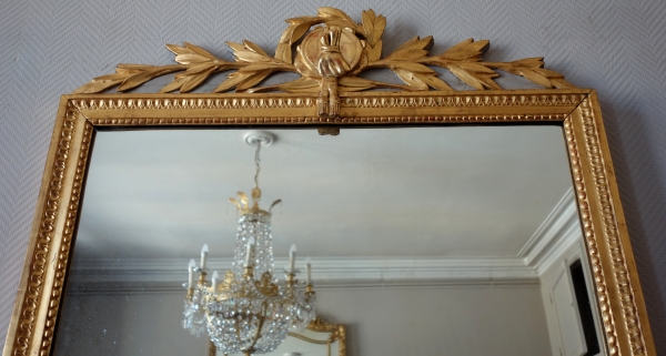 Grand miroir en bois doré d'époque Louis XVI, modèle Provençal avec fronton à trophée de musique