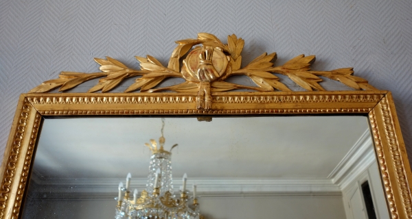 Grand miroir en bois doré d'époque Louis XVI, modèle Provençal avec fronton à trophée de musique