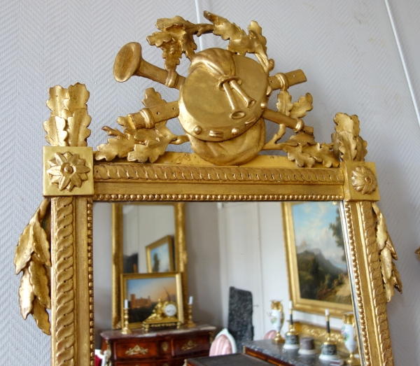 Grand miroir provençal d'époque Louis XVI en bois doré, fronton à trophée de musique