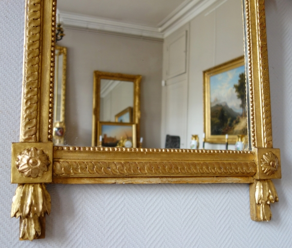 Grand miroir provençal d'époque Louis XVI en bois doré, fronton à trophée de musique