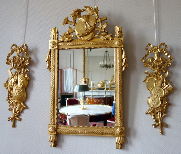 Grand miroir provençal d'époque Louis XVI en bois doré, fronton à trophée de musique