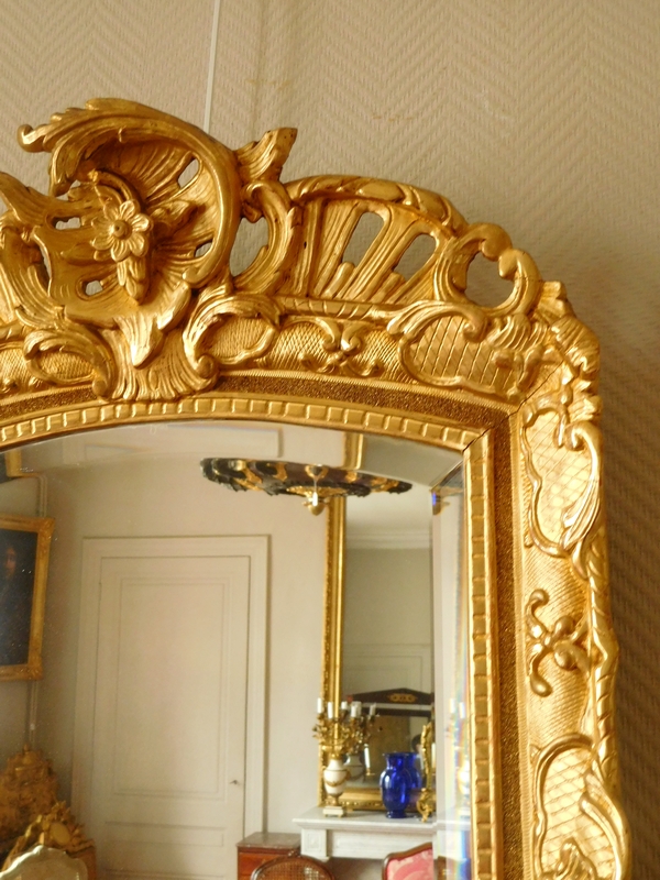 Miroir en bois doré d'époque Régence, glace biseautée