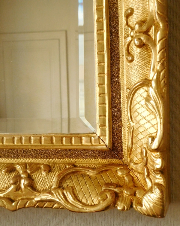 Miroir en bois doré d'époque Régence, glace biseautée