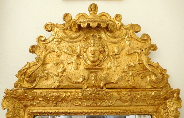 Miroir à fronton en bois doré d'époque Régence, masque d'Indienne, glace au mercure XVIIIe