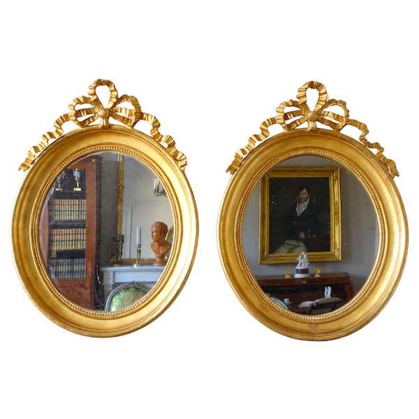 Pair of Louis XVI style gold leaf gilt wood oval mirrors, 19th century