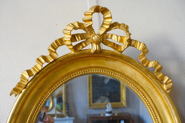 Paire de grands miroirs ovales en bois doré et glace au mercure de style Louis XVI