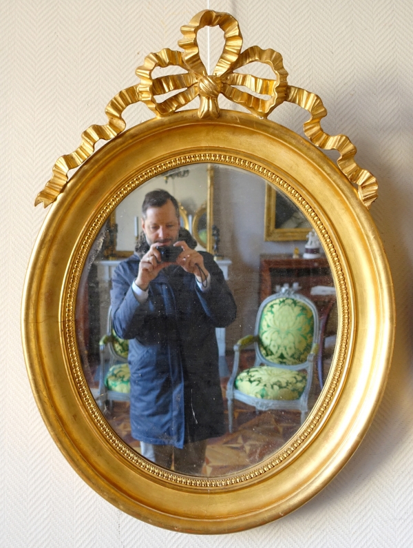 Pair of Louis XVI style gold leaf gilt wood oval mirrors, 19th century