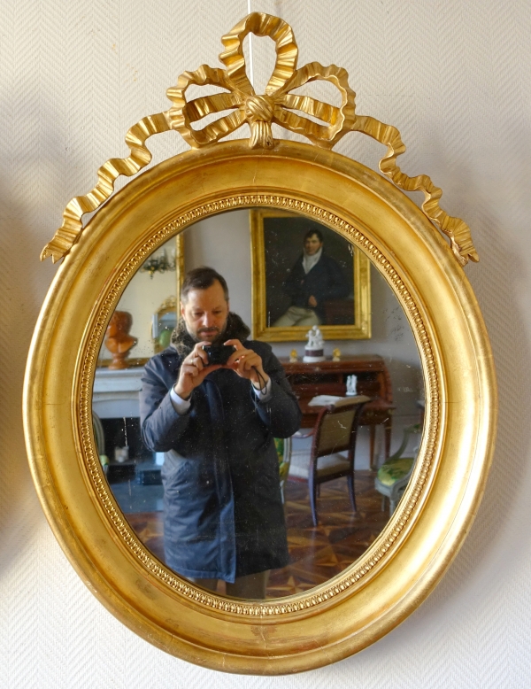 Pair of Louis XVI style gold leaf gilt wood oval mirrors, 19th century