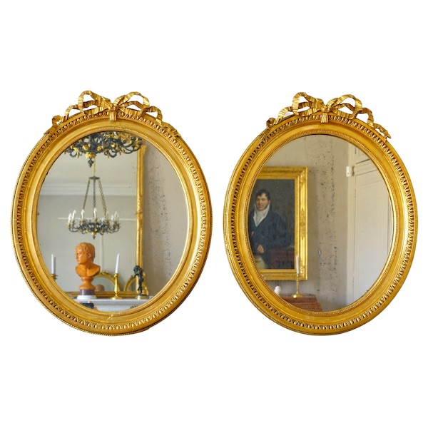 Pair of Louis XVI style gold leaf gilt wood oval mirrors, 19th century