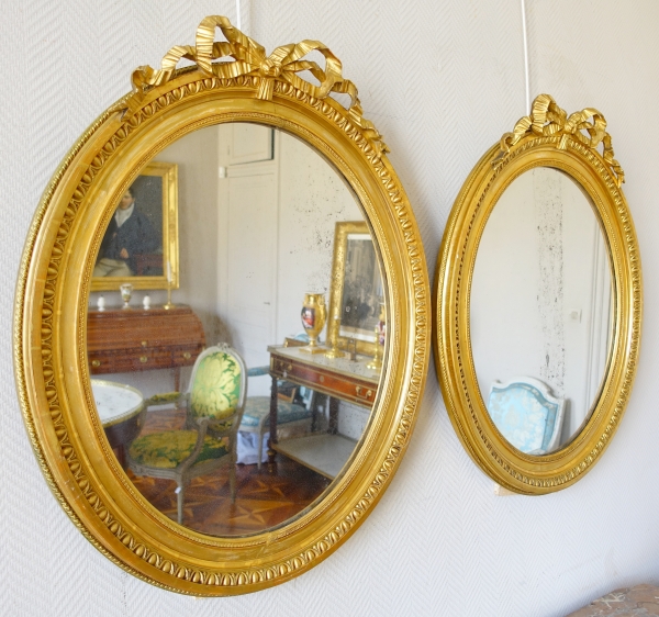 Pair of Louis XVI style gold leaf gilt wood oval mirrors, 19th century