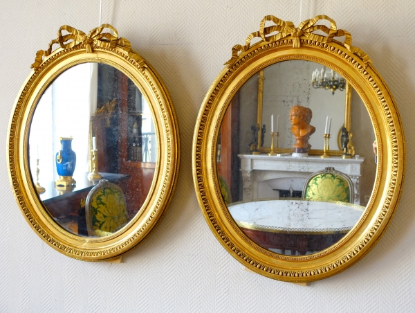 Pair of Louis XVI style gold leaf gilt wood oval mirrors, 19th century