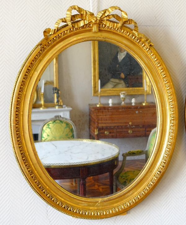 Pair of Louis XVI style gold leaf gilt wood oval mirrors, 19th century