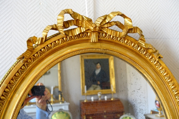 Pair of Louis XVI style gold leaf gilt wood oval mirrors, 19th century