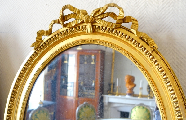 Pair of Louis XVI style gold leaf gilt wood oval mirrors, 19th century