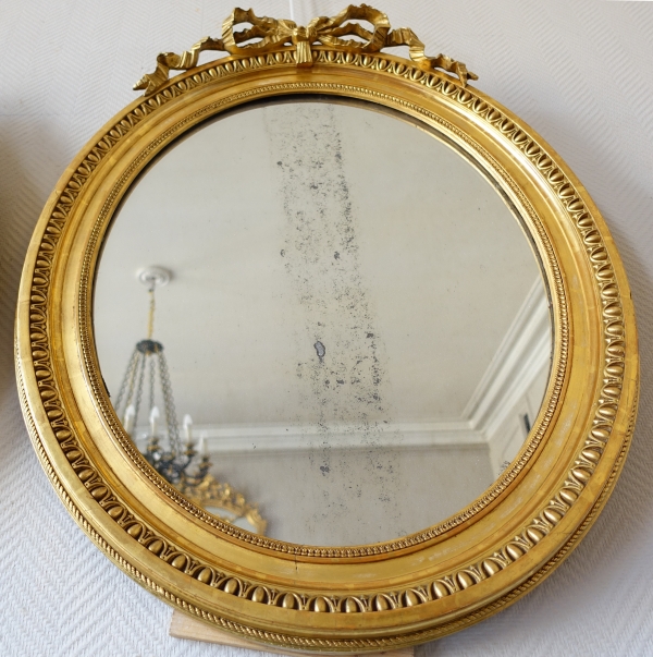 Pair of Louis XVI style gold leaf gilt wood oval mirrors, 19th century