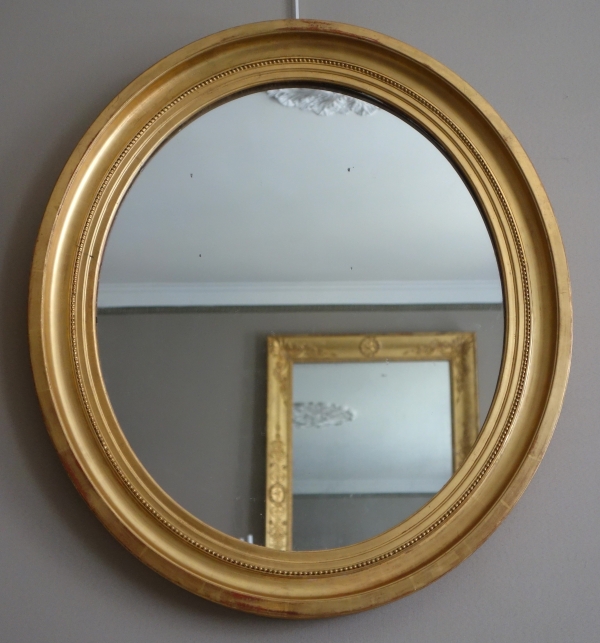 Paire de grands miroirs ovales en bois doré, glace au mercure - style Louis XVI