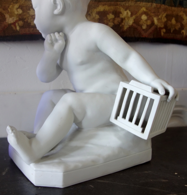 Tall porcelain biscuit : child with a cage after Jean Baptiste Pigalle - 36cm