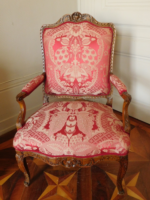 Fauteuil à la Reine richement sculpté d'époque Régence vers 1730, garniture de soie rouge