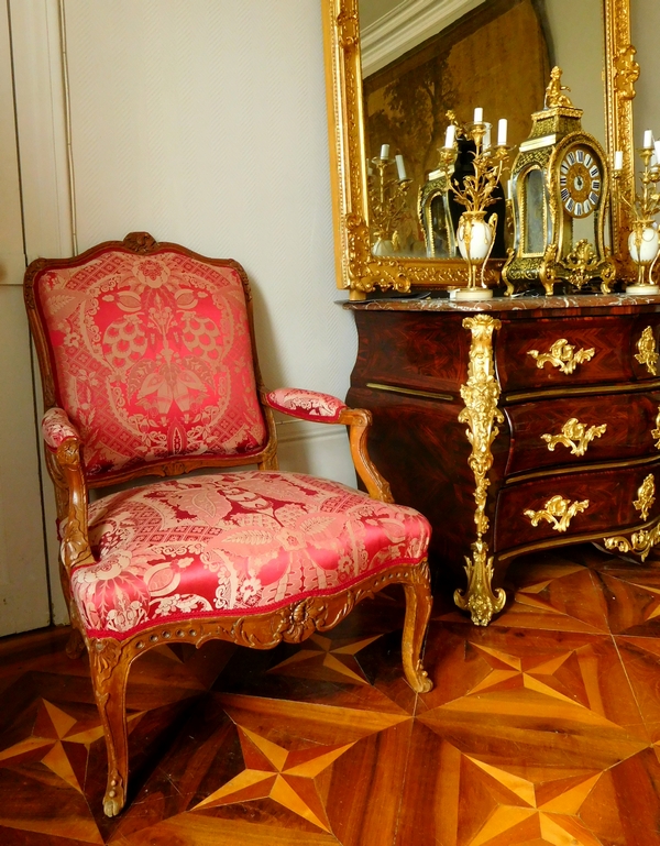 Fauteuil à la Reine richement sculpté d'époque Régence vers 1730, garniture de soie rouge