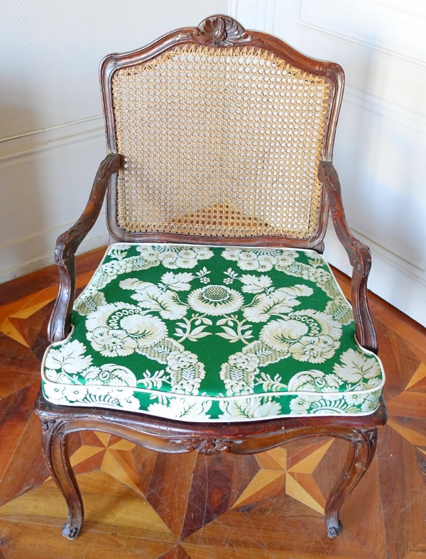 Fauteuil canné d'époque Régence Louis XV à coussin de soie