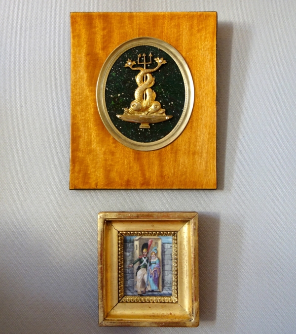 Miniature trophée de dauphins en bronze doré sur fond porphyre dans cadre en citronnier