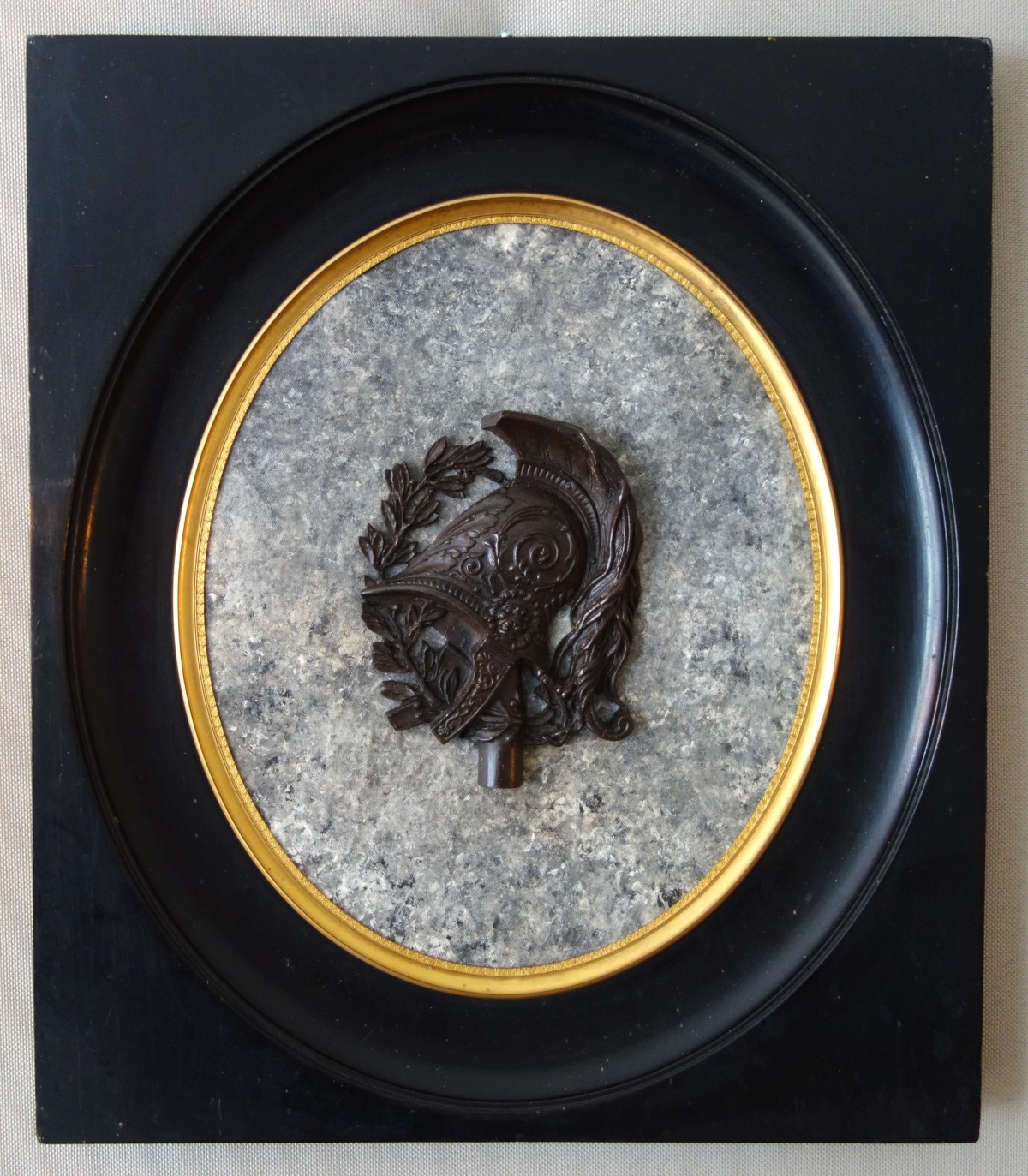 Detail — Large miniature, patinated bronze military trophee on a granite background